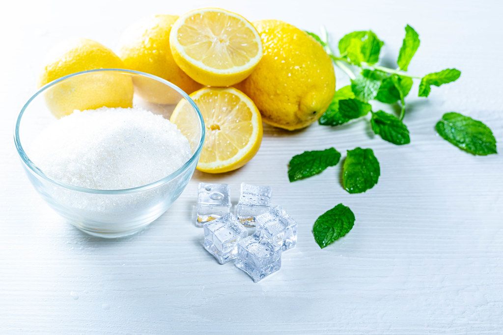 Ingredients for lemonade - sugar, lemons, mint leaves and ice