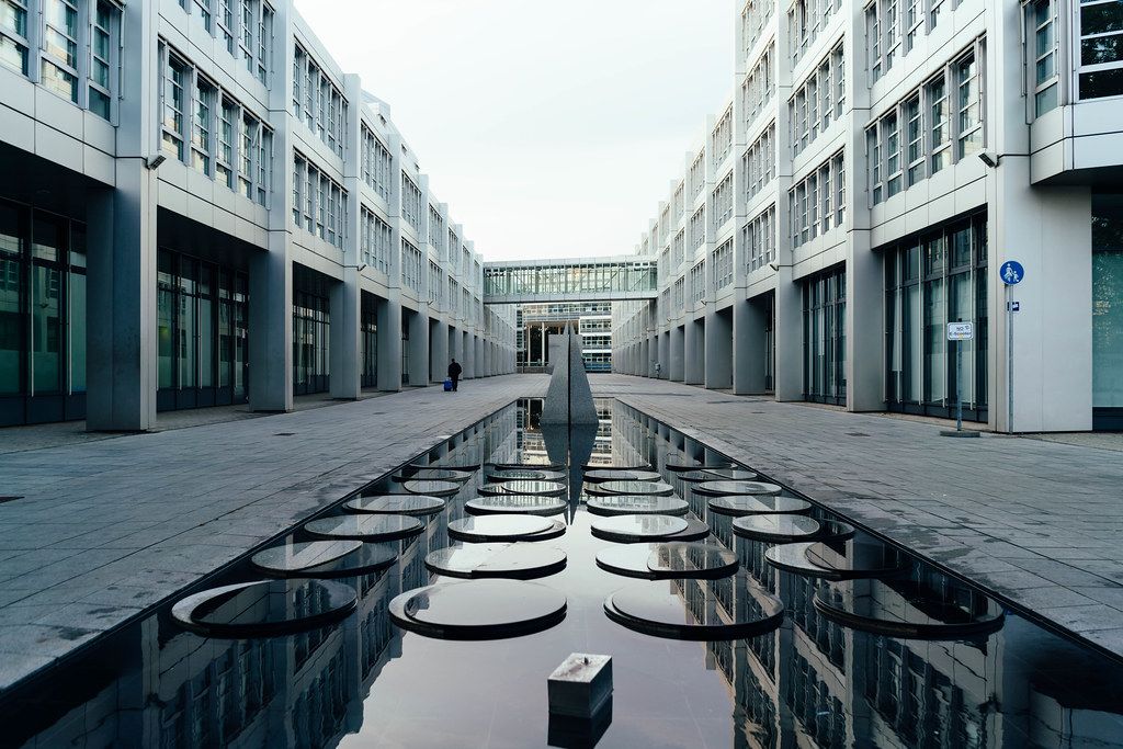 Inner yard of modern architecture building with fountain and sculpture in Munich, Germany