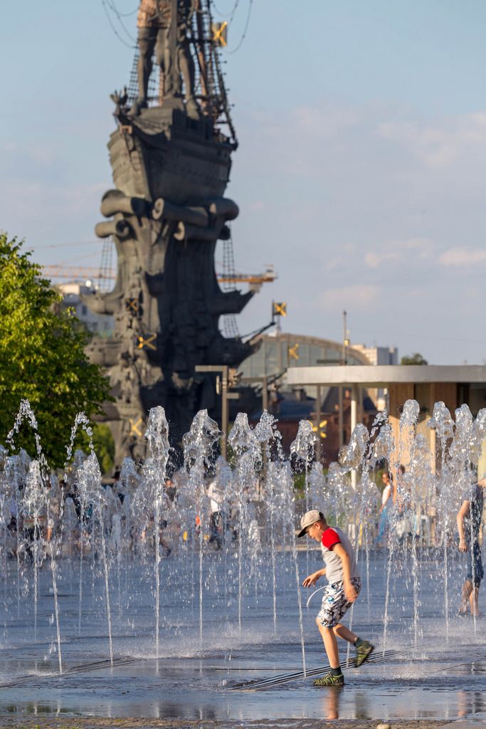 Junge spielt im Springbrunnen unweit des Denkmals für Peter I.