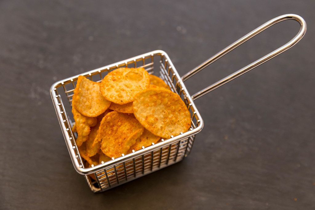 Knusprige Kartoffelchips von IronMaxx als gesunder Snack für Sportler mit Paprikagewürz und viel Eiweiß,  in einem kleinen Fritierkorb