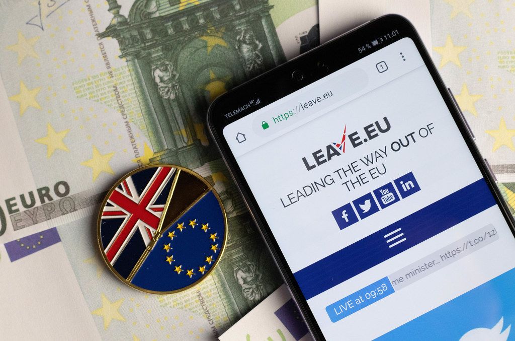 Leave.eu Homepage auf dem Smartphone mit dem Brexit-Symbol auf einer Münze und Euroscheine