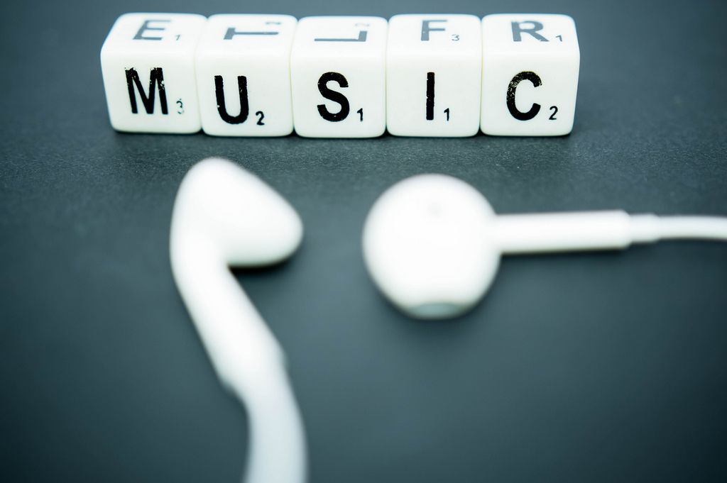 Letter dice reading MUSIC with earphones