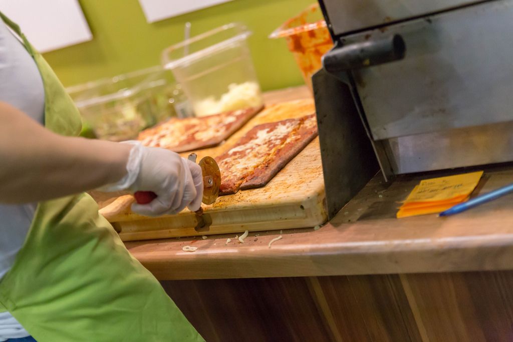 Lizza Low-Carb Pizza wird in kleine Stücke geschnitten