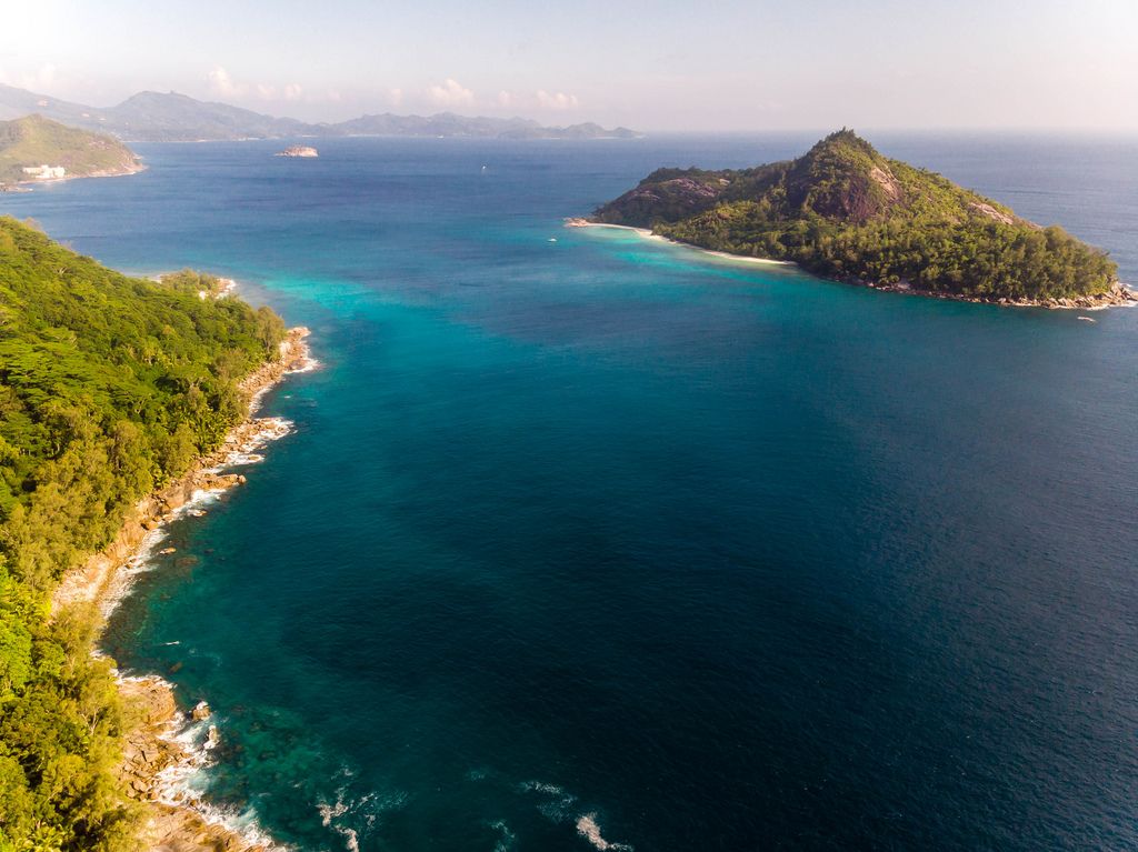 Luftaufnahme von der Seychelleninsel Therese umgeben vom blauen Ozean, aus Richtung Anse des Anglais im Constance Ephelia Resort, Mahé