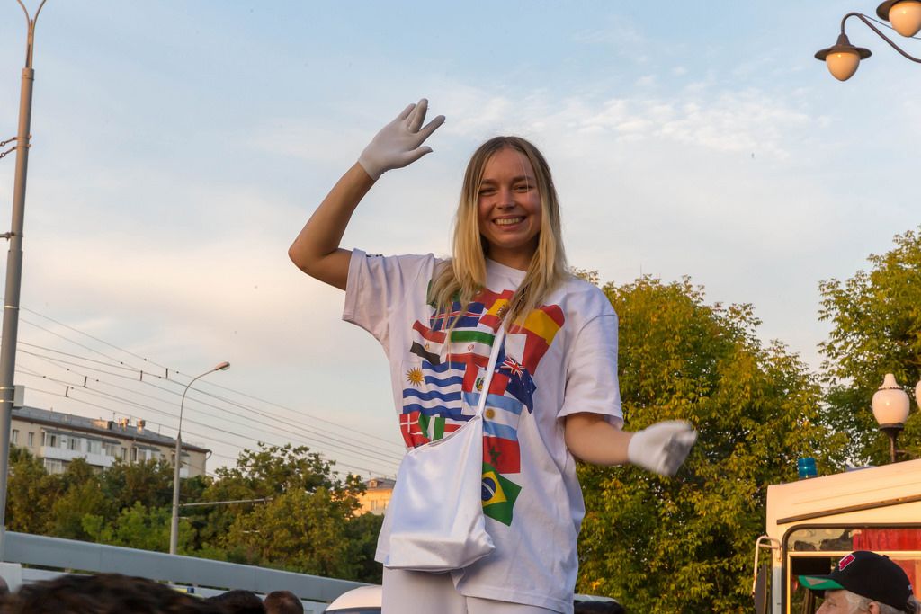 Mädchen mit weißen Handschuhen und T-Shirt mit diversen Nationalflaggen