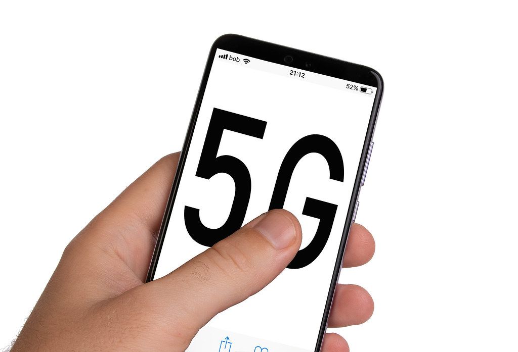 Male hands holding smartphone with 5G text