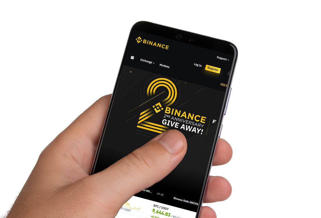 Male hands holding smartphone with an open Binance application