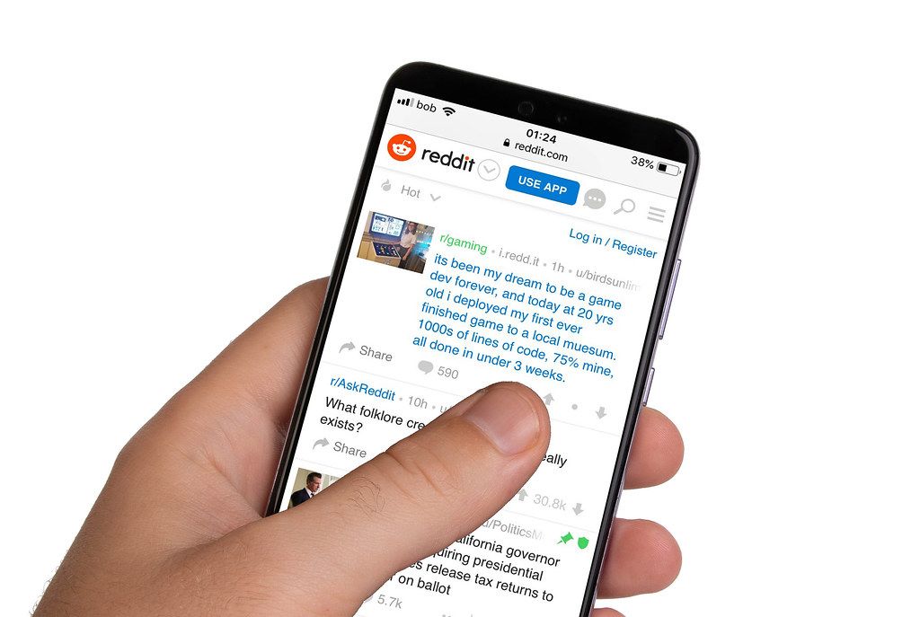 Male hands holding smartphone with an open Reddit application