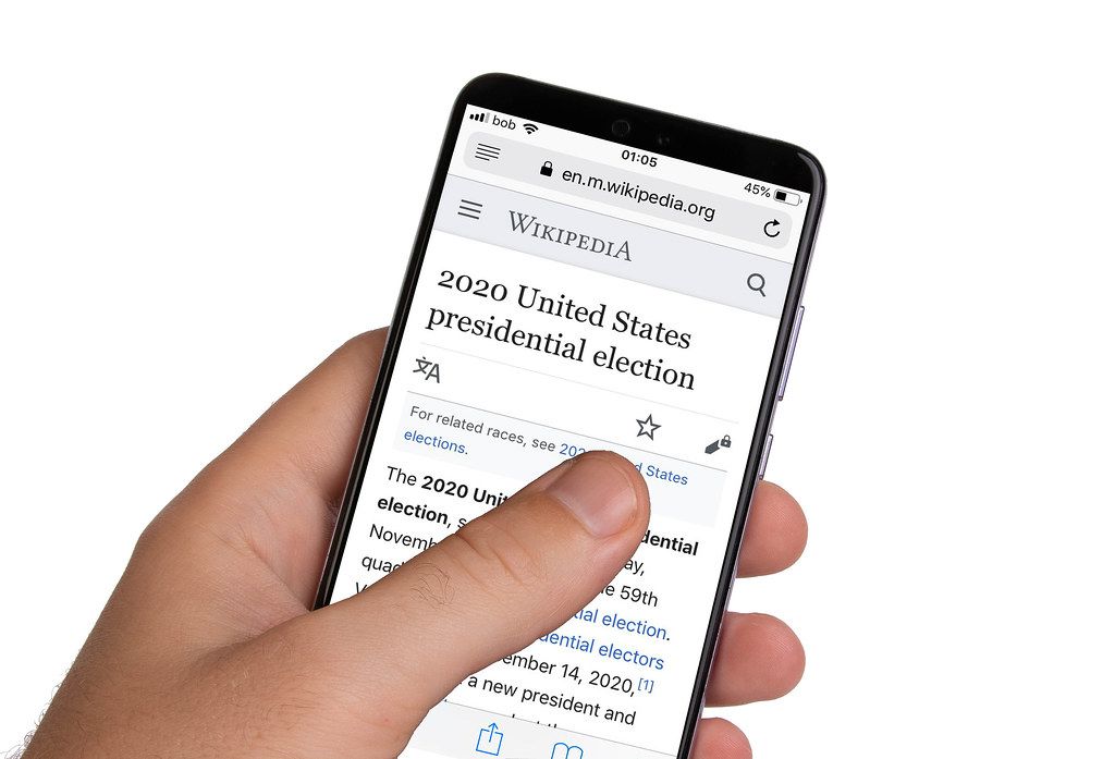 Male hands holding smartphone with an open Wikipedia application