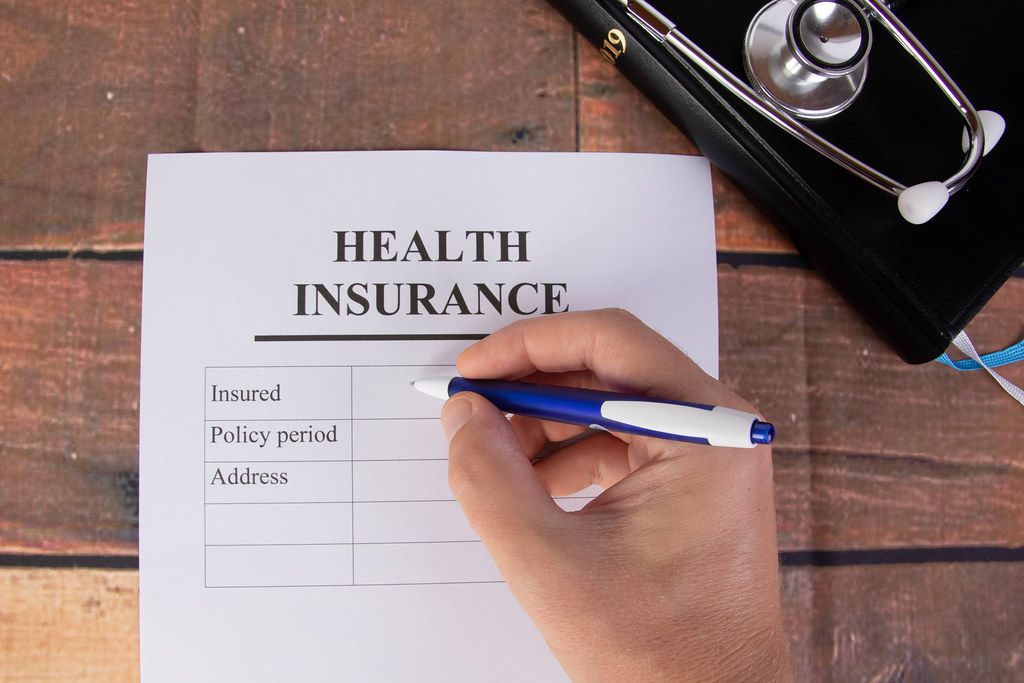 Man filling out health insurance form