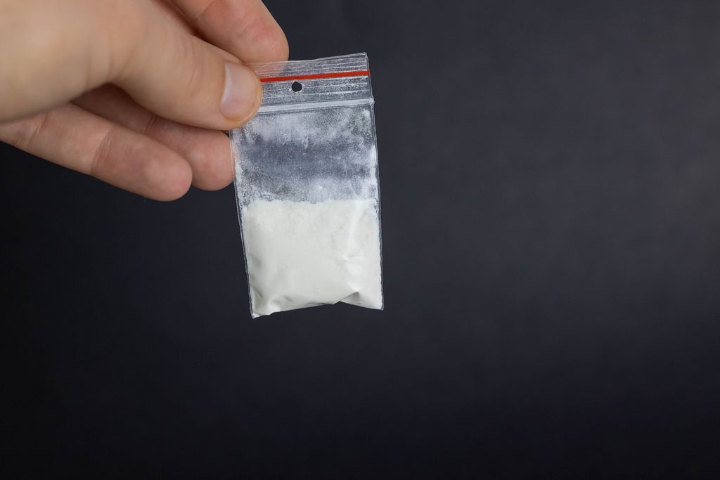 Man holding pack of cocaine