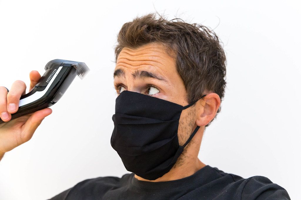 Man with black face mask cuts his own hair at home with a Philips QC5115/15 hair clipper