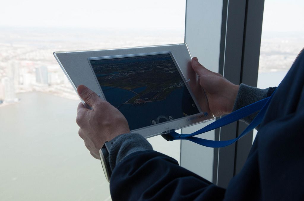 Mann hält Tablet mit einem Foto von Jersey City in den Händen, USA