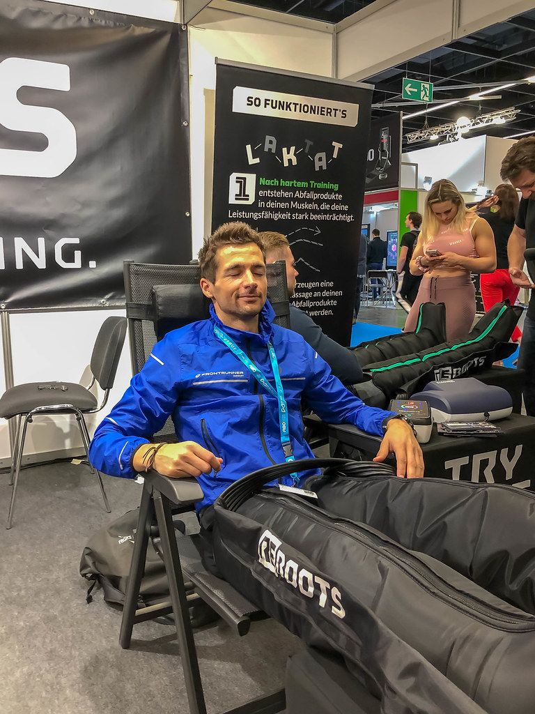 Mann relaxiert durch die regenerierende Massage von ReBoots auf Kölner Fitnessmesse