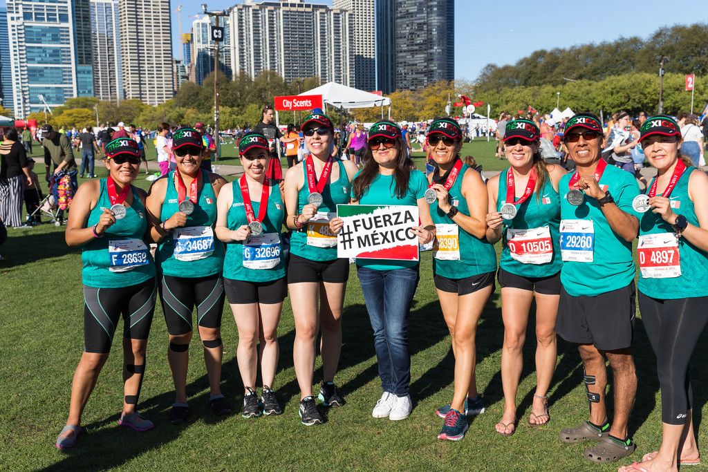 Marathonläuferinnen halten ein Transparent mit dem Fuerza Mexico Hashtag