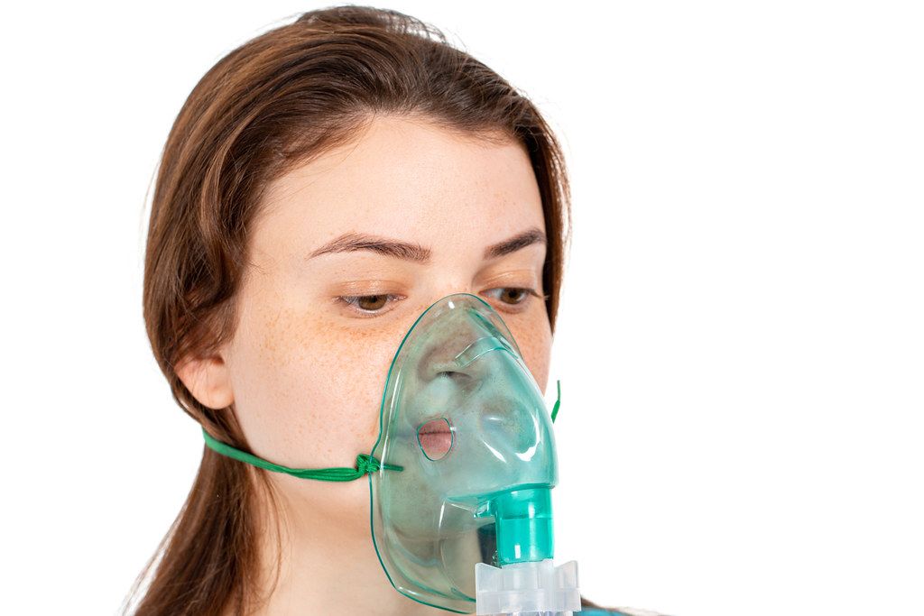 Mask for inhalation on the girl's face. Respiratory disease treatment concept