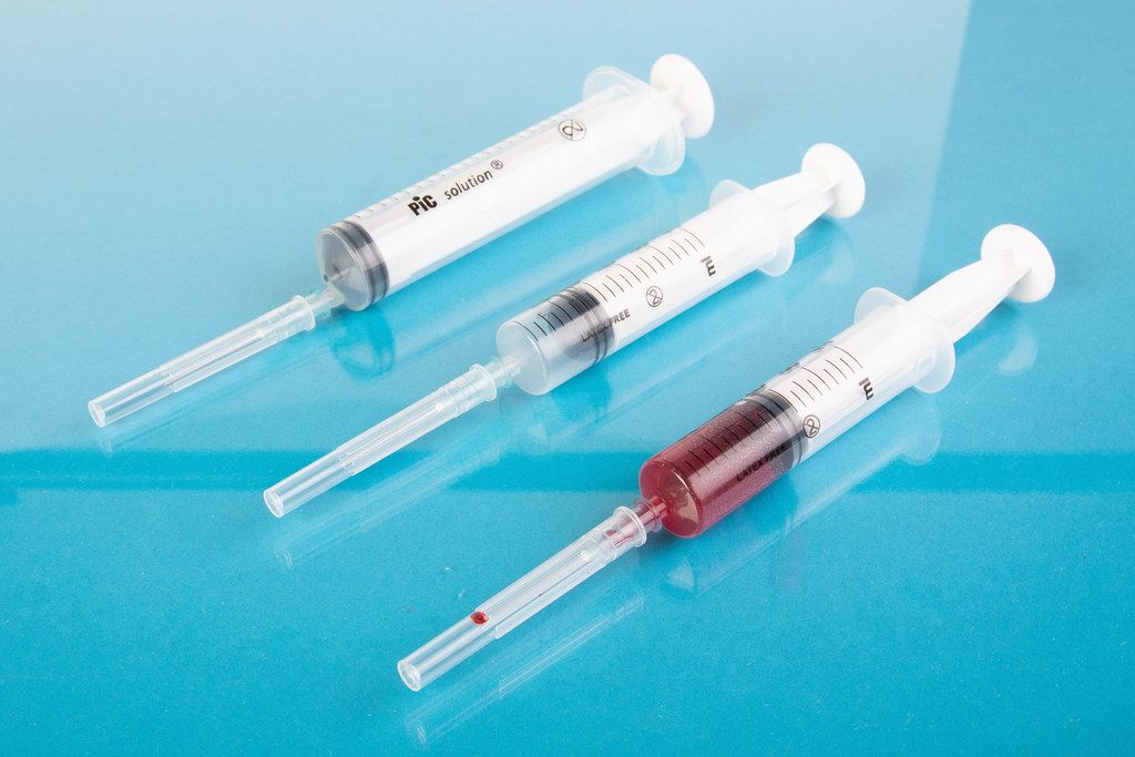 Medical syringes in a row on a blue background