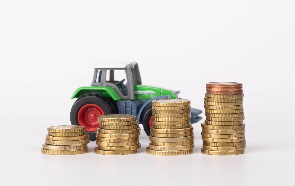 Metal coin stacks and tractor on white background