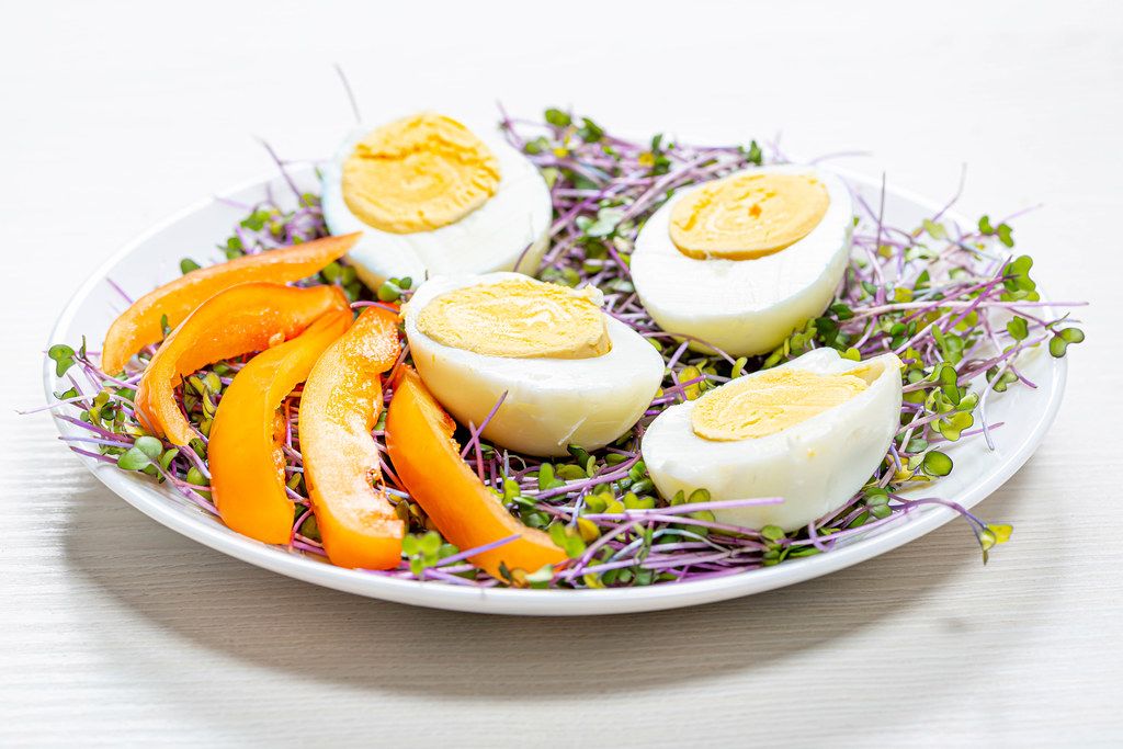 Micro-greens cabbage with boiled eggs and pieces of bell pepper