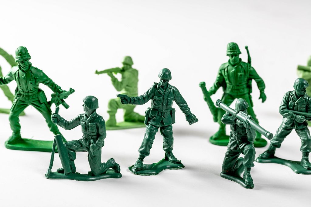 Miniature toy soldiers with guns on white background