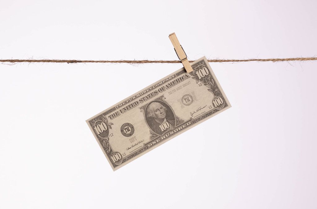 Money with wooden clothespin on clothes line