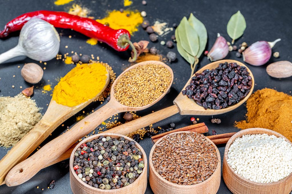 Multi-colored spices for healthy and tasty cooking on a black background
