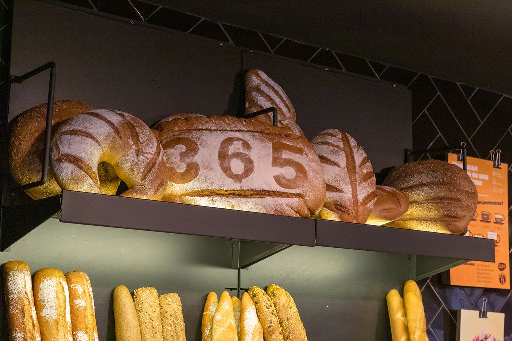 Muster im Mehl wirbt für frischgebackenes Brot im 365 Café an der Einkaufsstraße Carrer de Joaquín Costa in Barcelona, Spanien