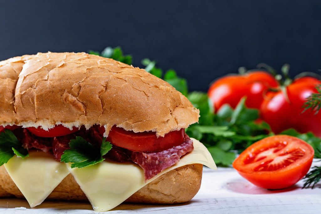 Nahaufnahme und Seitenansicht von einem belegten Sandwich mit Salami ...
