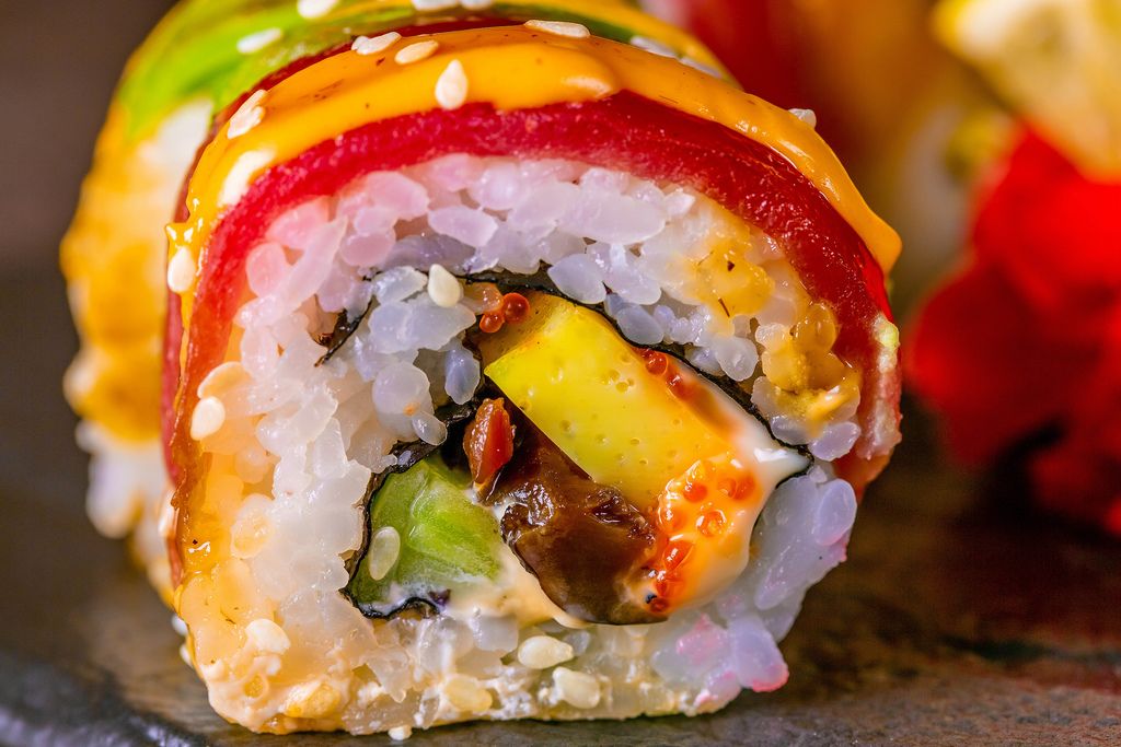 Sushi Rollen gefüllt mit grünem Paprika und Lachs im weißen HIntergrund ...