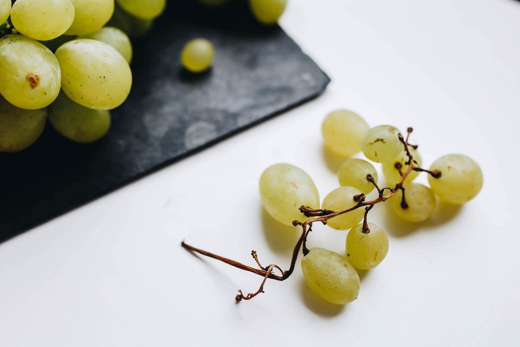 Nahaufnahme von weißen Weintrauben vor weißem Hintergrund