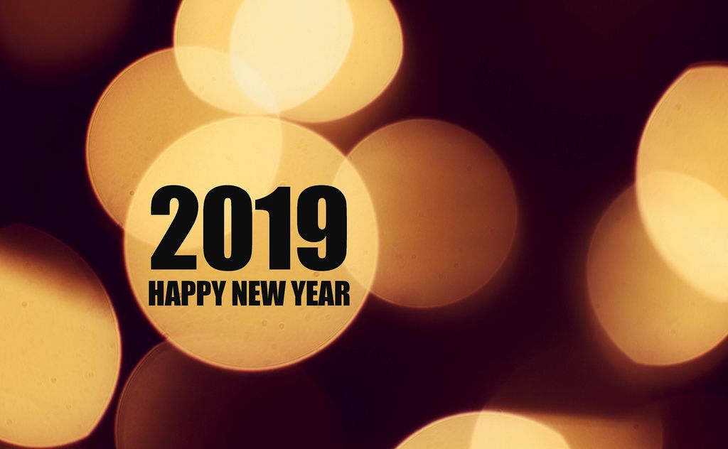 Neujahrsbotschaft 2019 HAPPY NEW YEAR in schwarzen Buchstaben auf hellen Lichtkreisen