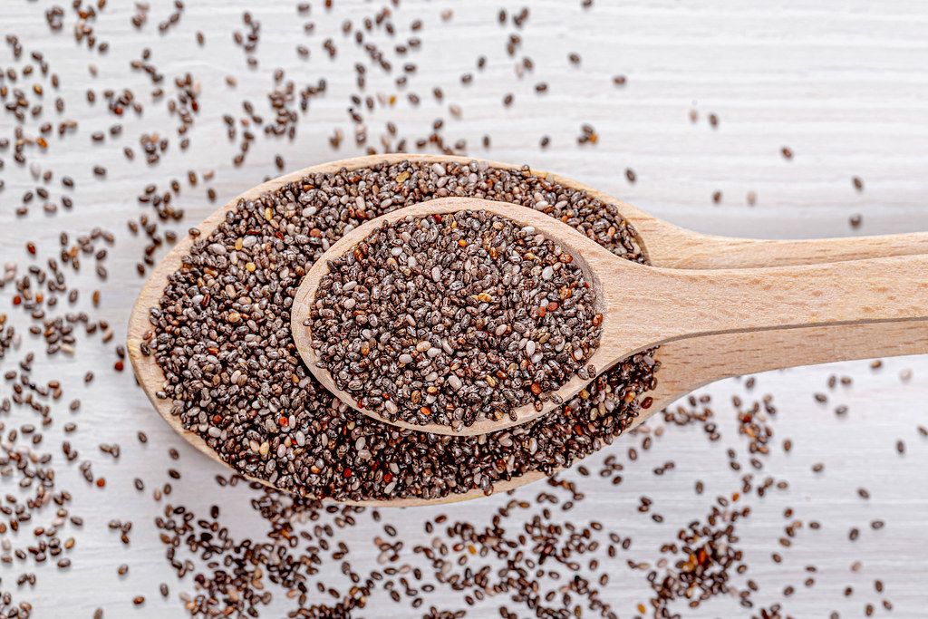 Nutritious chia seeds on a wooden spoons. Top view