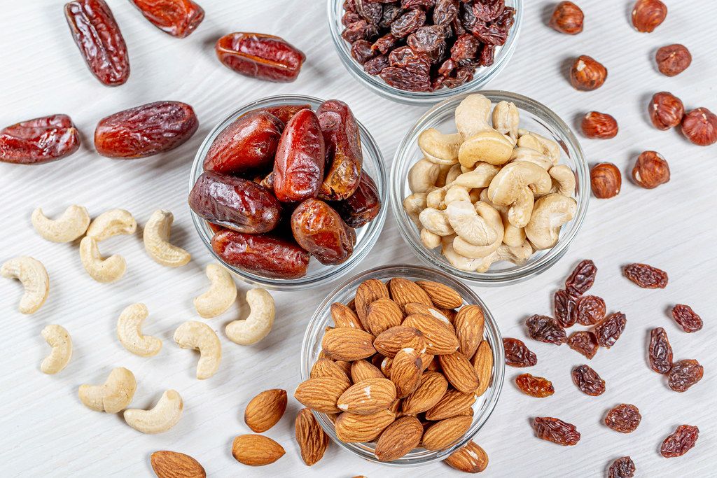 Nuts and dried fruits on a white wooden background. The concept of healthy food