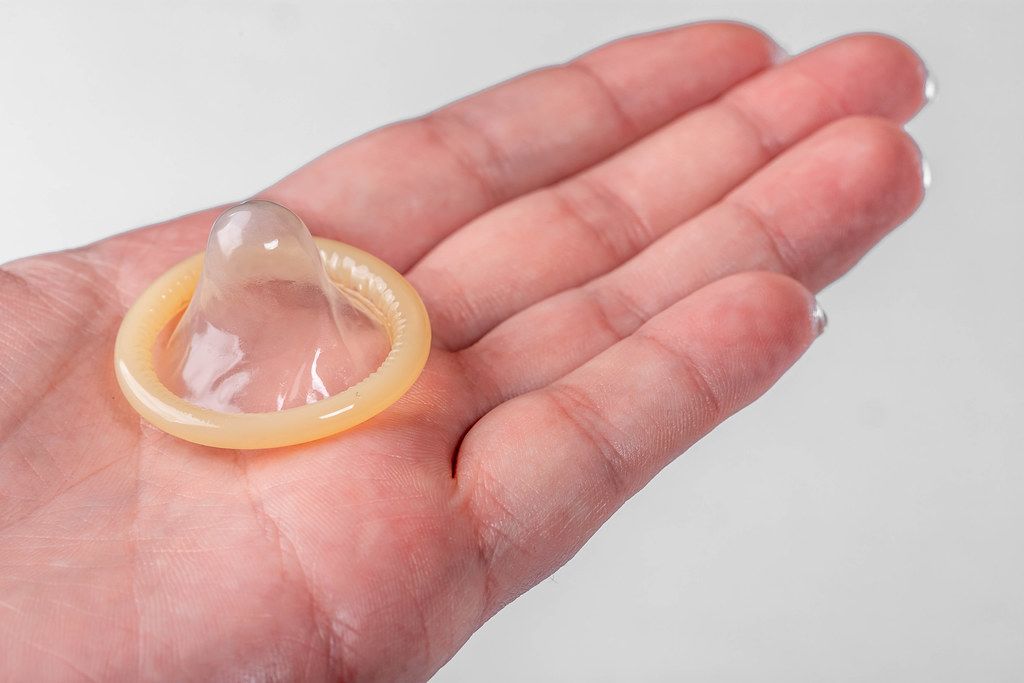 On the hand of a man condom on a white background (Flip 2019)