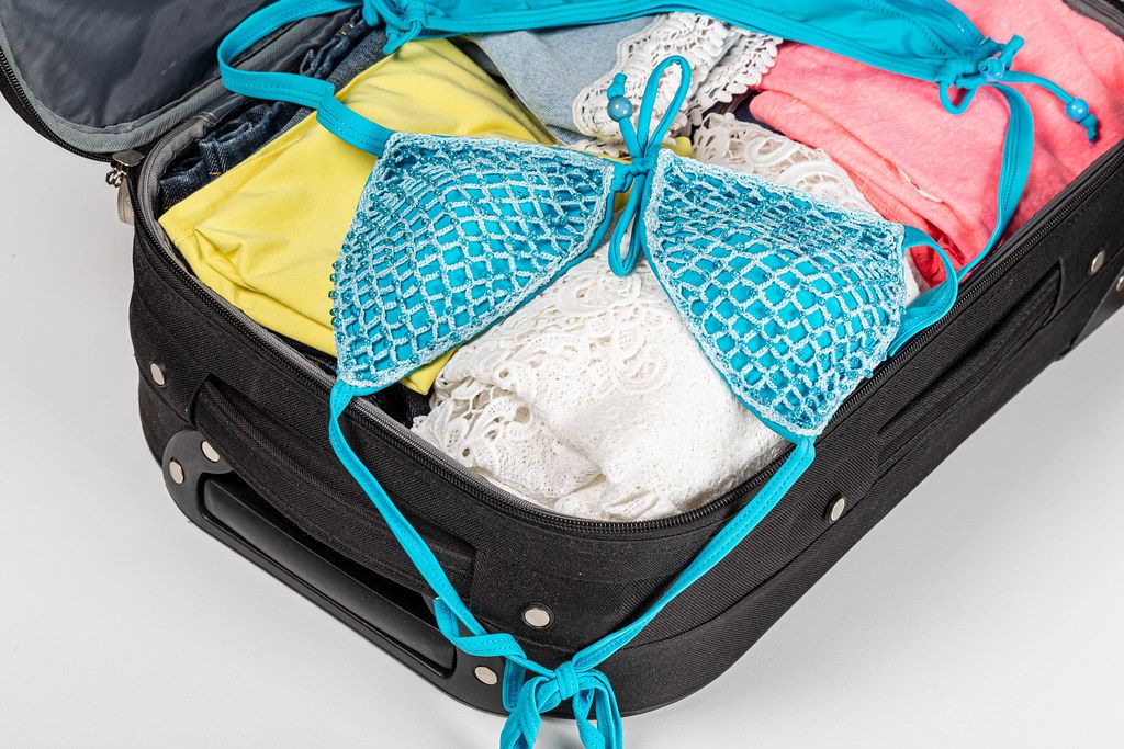 open suitcase with beach or summer clothes