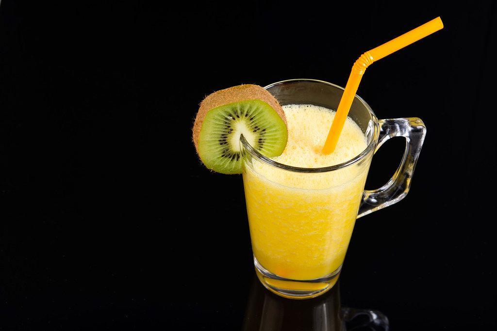 Orange juice with Kiwi in the glass on the black background