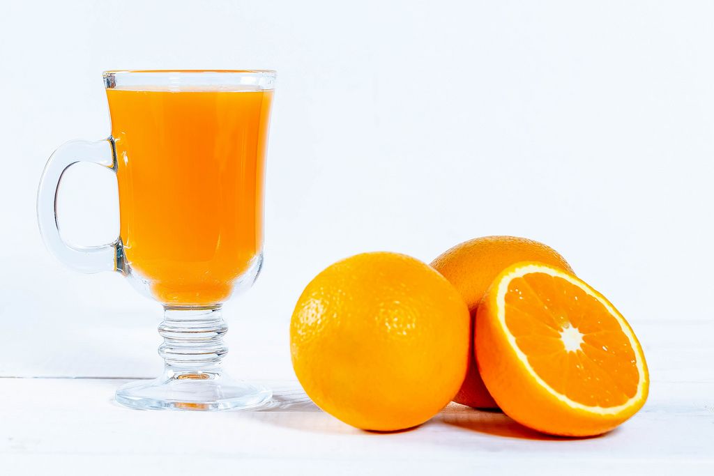 Oranges and a glass of juice on a white background