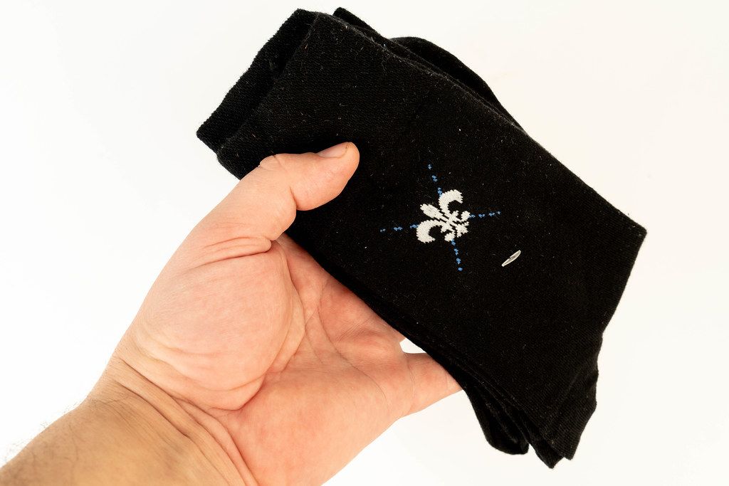 Packed Black Socks in the hand above white background