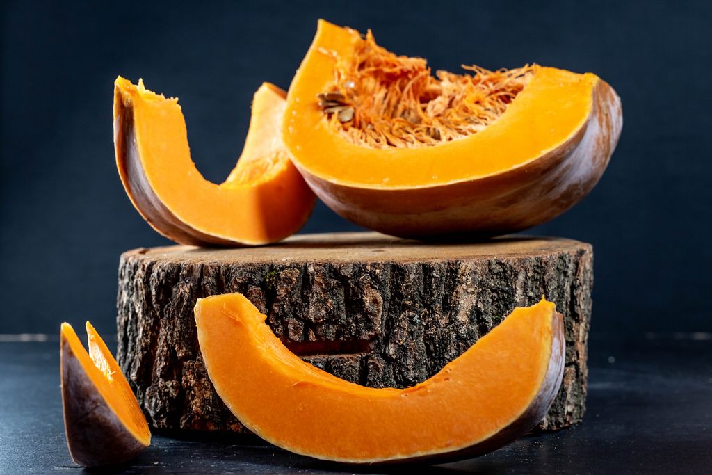 Pieces of ripe orange pumpkin on a wooden stump