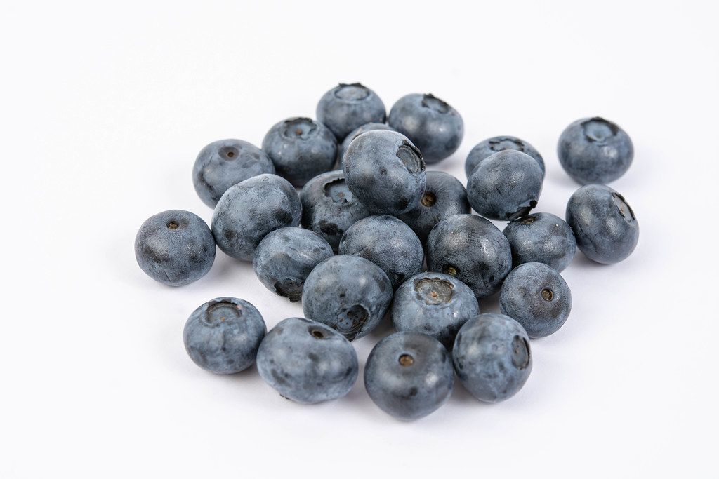 Pile of Fresh Whole Blueberries above white background