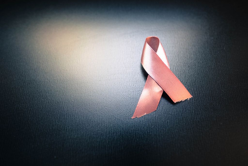 pink cancer awareness ribbon on black background