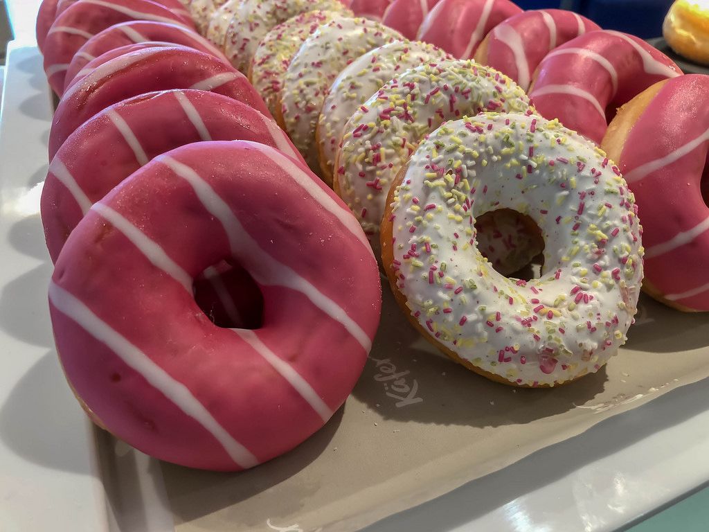 Pink-weiß gestreifte und gestreuselte Donuts