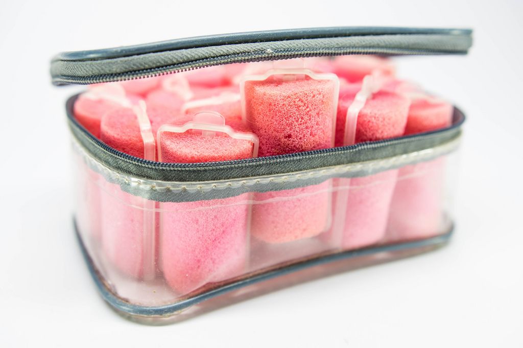 Plastic case with many pink sponge hair curlers
