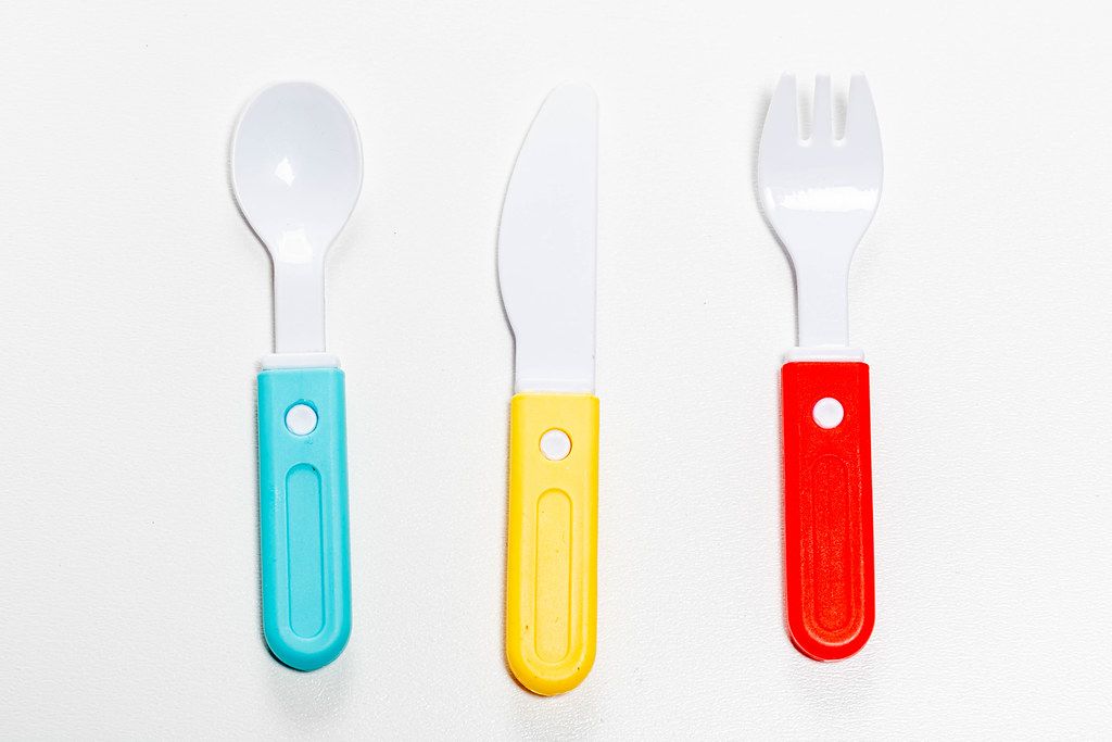 Plastic knife, fork and spoon on white background. Children's toy