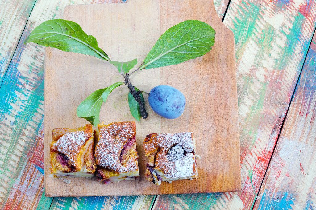 Plum cakes with fresh plum fruit on a wooden background (Flip 2019)