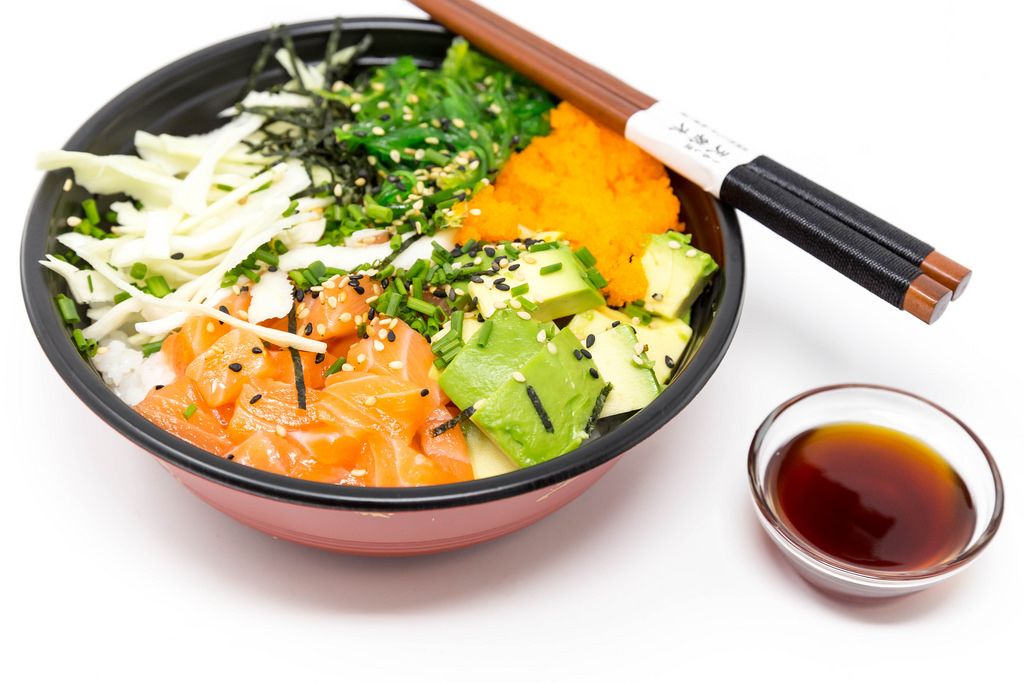 Poke Bowl Salmon Teriyaki  - with sushi rice, salmon, avocado, cabbage, wakame, wasago, nori, teriyaki-sauce, soy-sauce, sesame and chives in a bowl with chopsticks