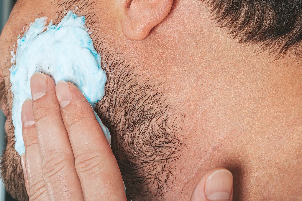 Portrait eines Mannes - Rasierschaum auf seinem Bart - Pflegekonzept