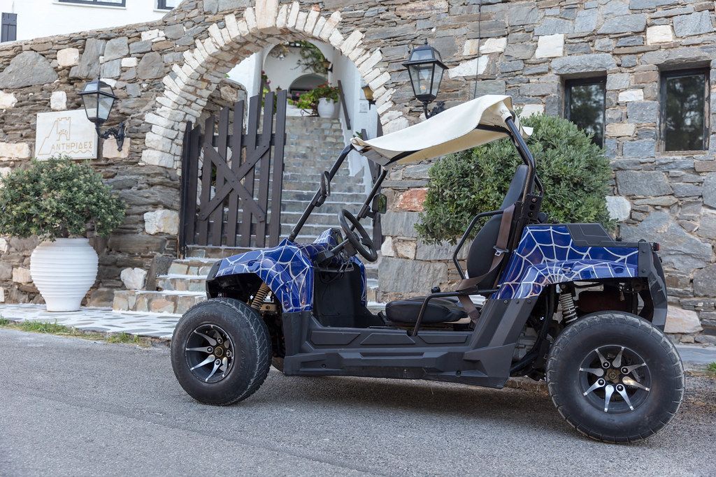 Quad-Leihfahrzeug vor der Steinmauer des Hotels Antirides, auf der Mittelmeerinsel Paros, Griechenland