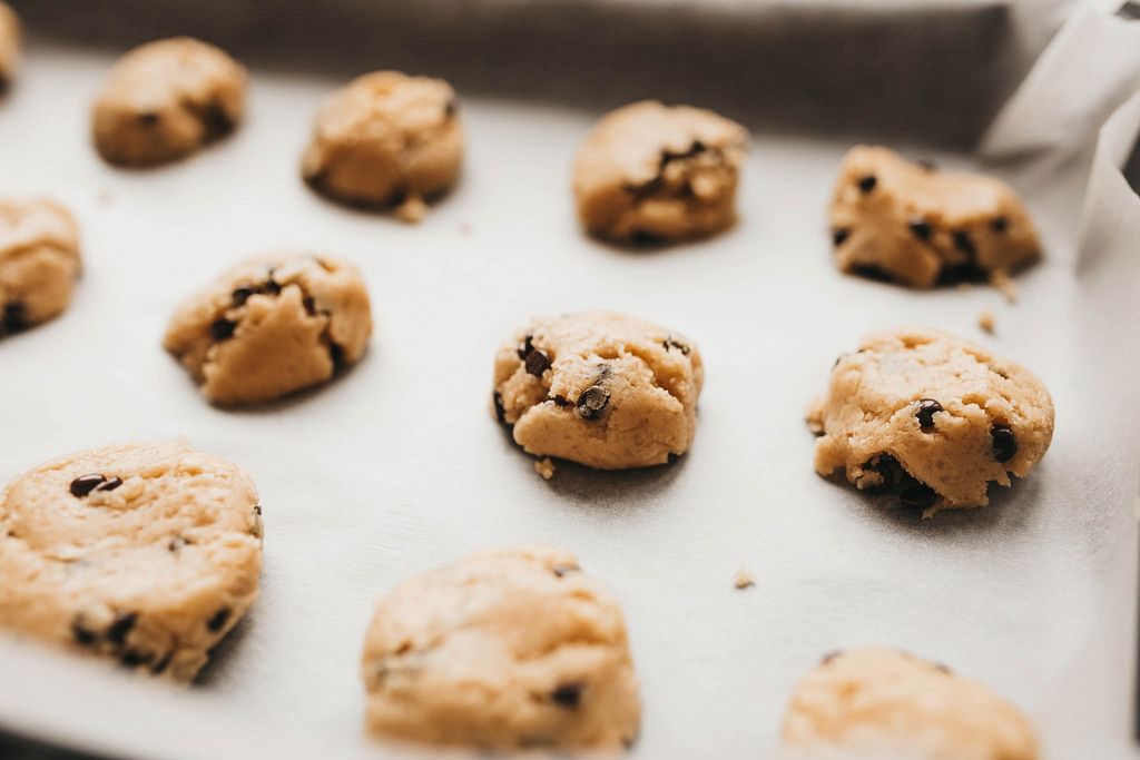 Raw cookie dough with chocolate chips on a baking paper.