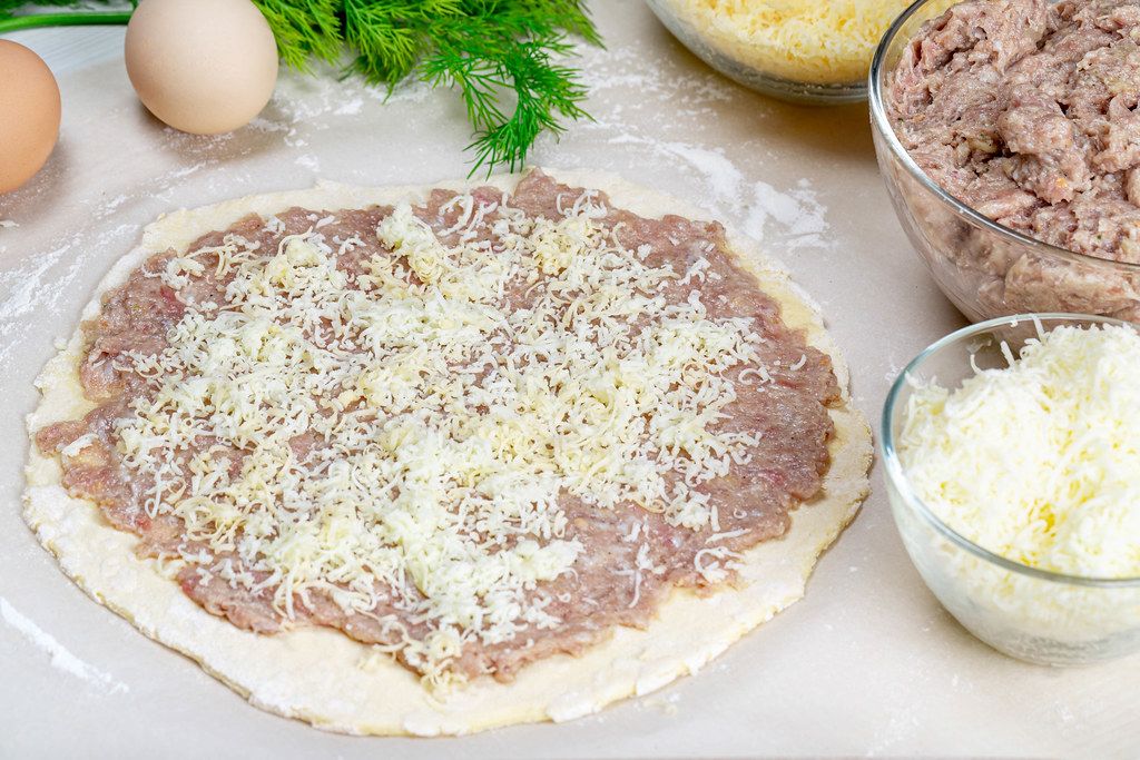 Raw dough with minced meat and cheese. Cooking concept